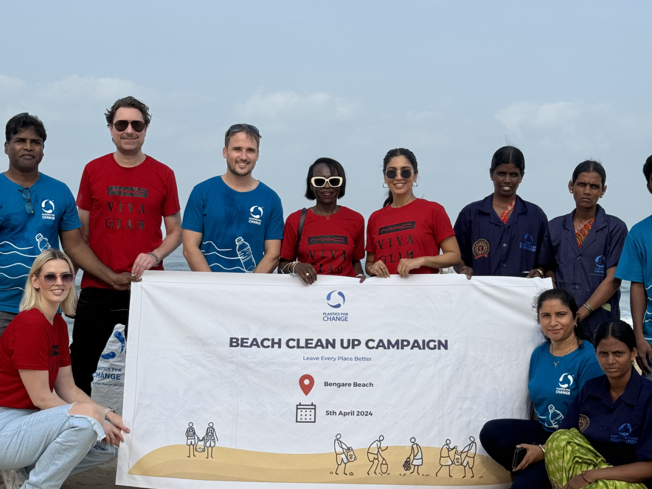 Volunteers pose with Beach clean up campaign banner
