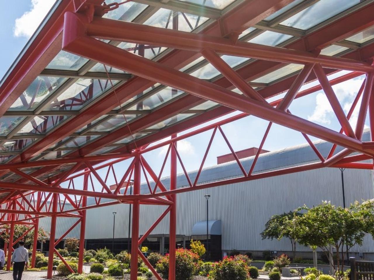 Exterior red support beams covering a walkway.