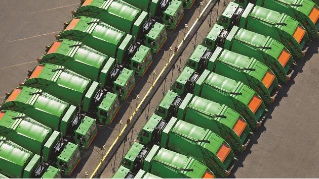 aerial view of two rows of green garbage trucks