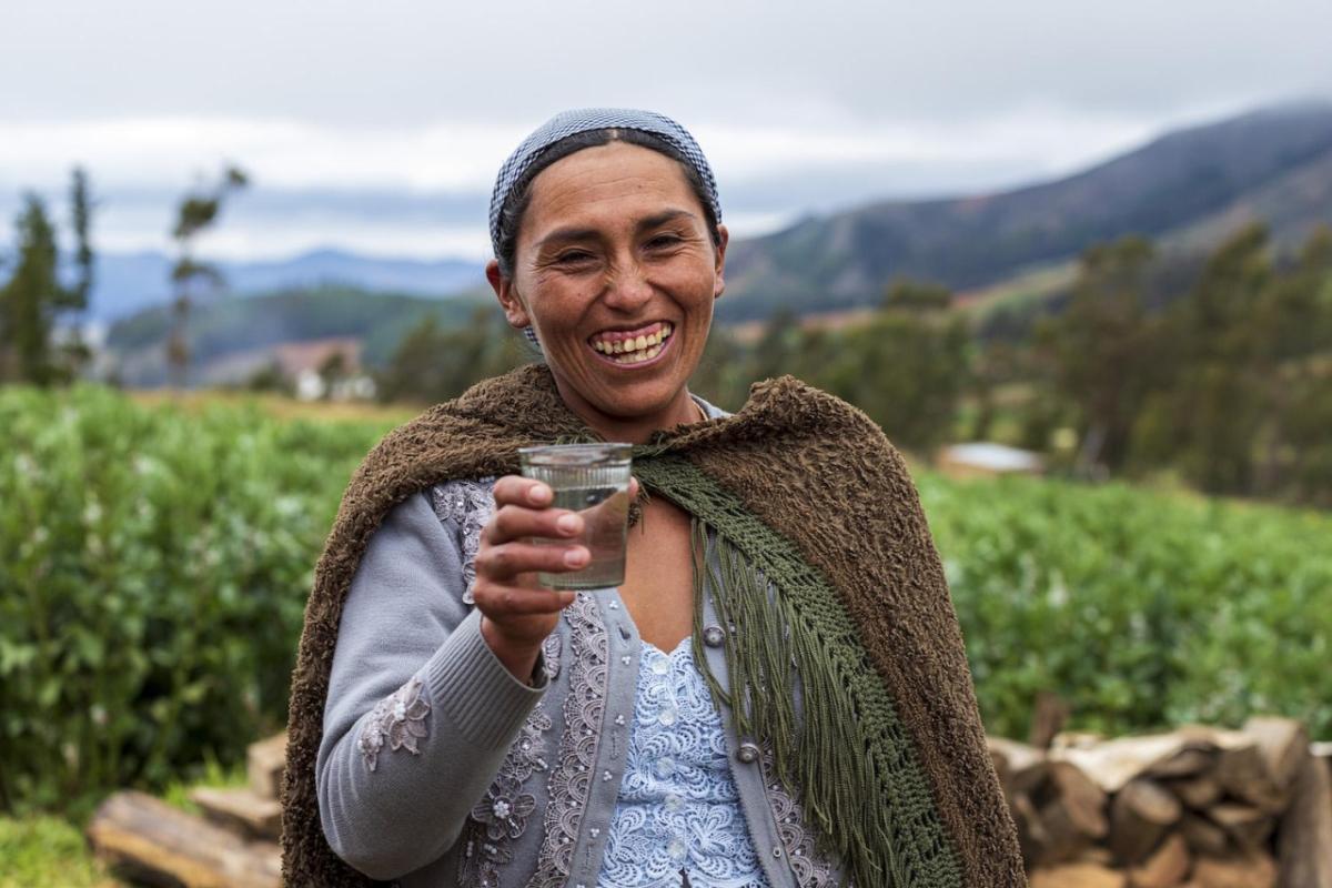 A Bolivian woman holds a glass of clean water from a new supply system installed by Water For People with funding from Kimberly-Clark.