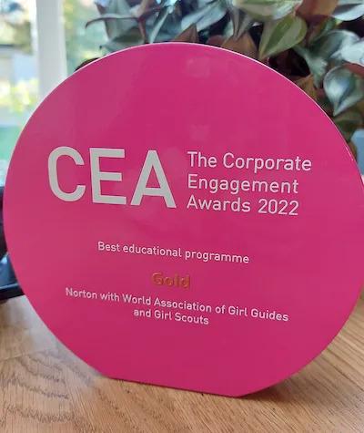 CEA Award. Pink, circular, with white writing "The Corporate Engagement Awards 2022.Best educational programme Gold"