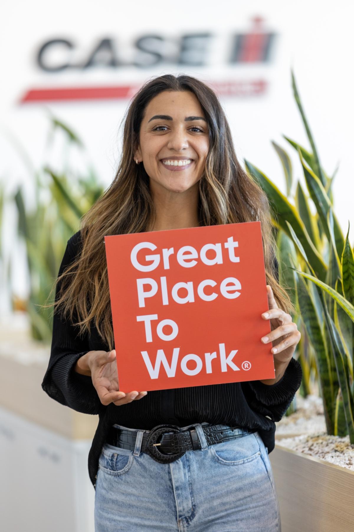 person holding a sign saying "Great Place to Work"
