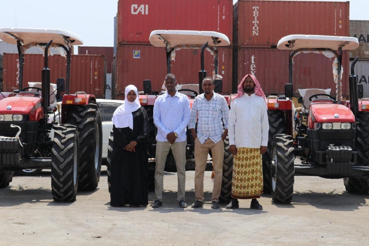 Gaalooge team members standing in front of several tractors