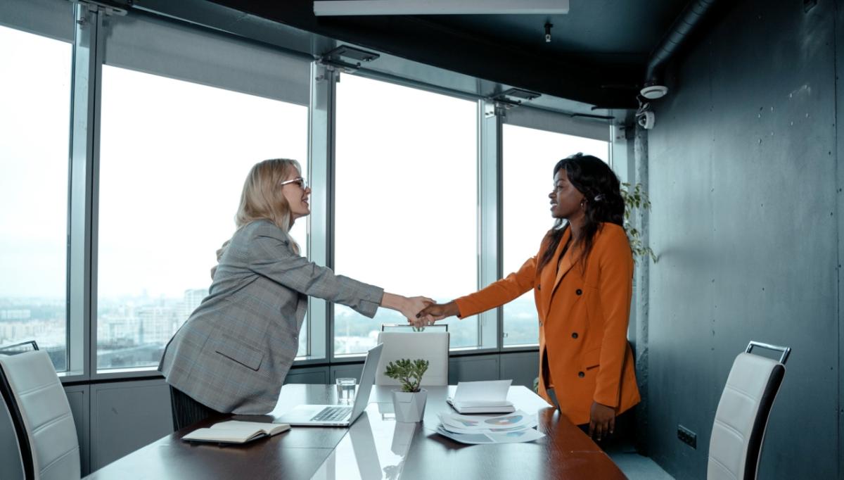 Woman shaking another woman's hand in an office