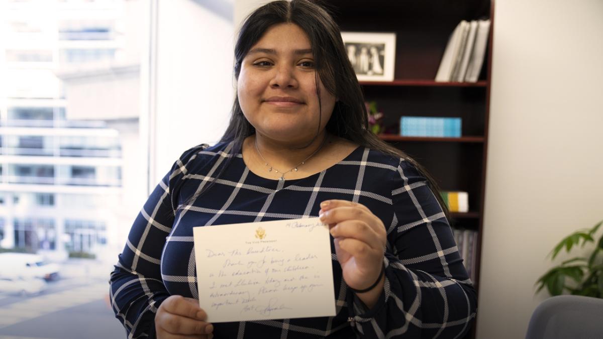 Llulisa, an Internet Essentials customer since freshman year of high school, holding up a hand written letter