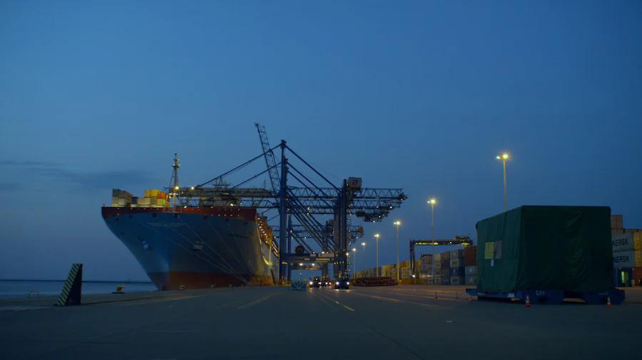 night time at a shipping dock, a large barge on the left