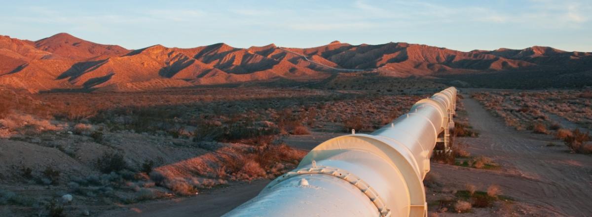 a large pipeline through a desert and mountain landscape
