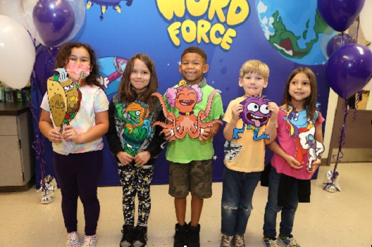 Five kids with crafts in front of "Word Force" banner