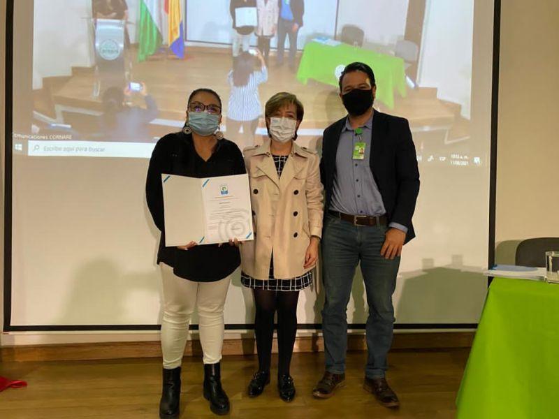 Group of three people holding certification in front of projector