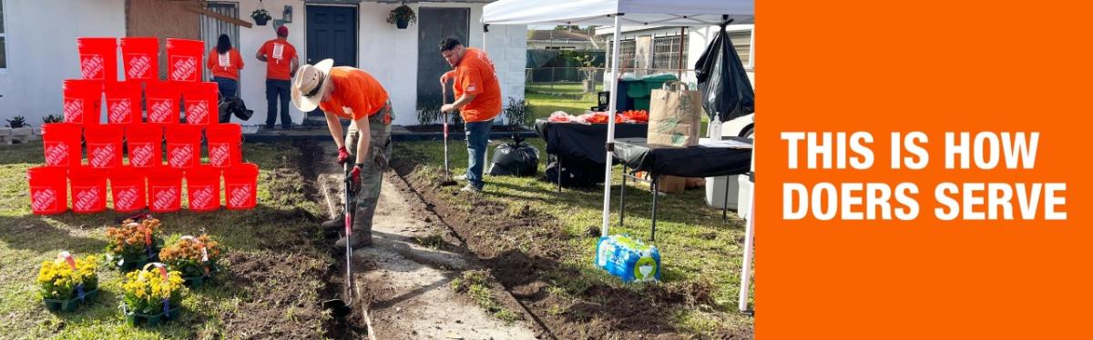 This is how doers serve. Team Depot volunteers are working on the front of a house and performing landscaping.