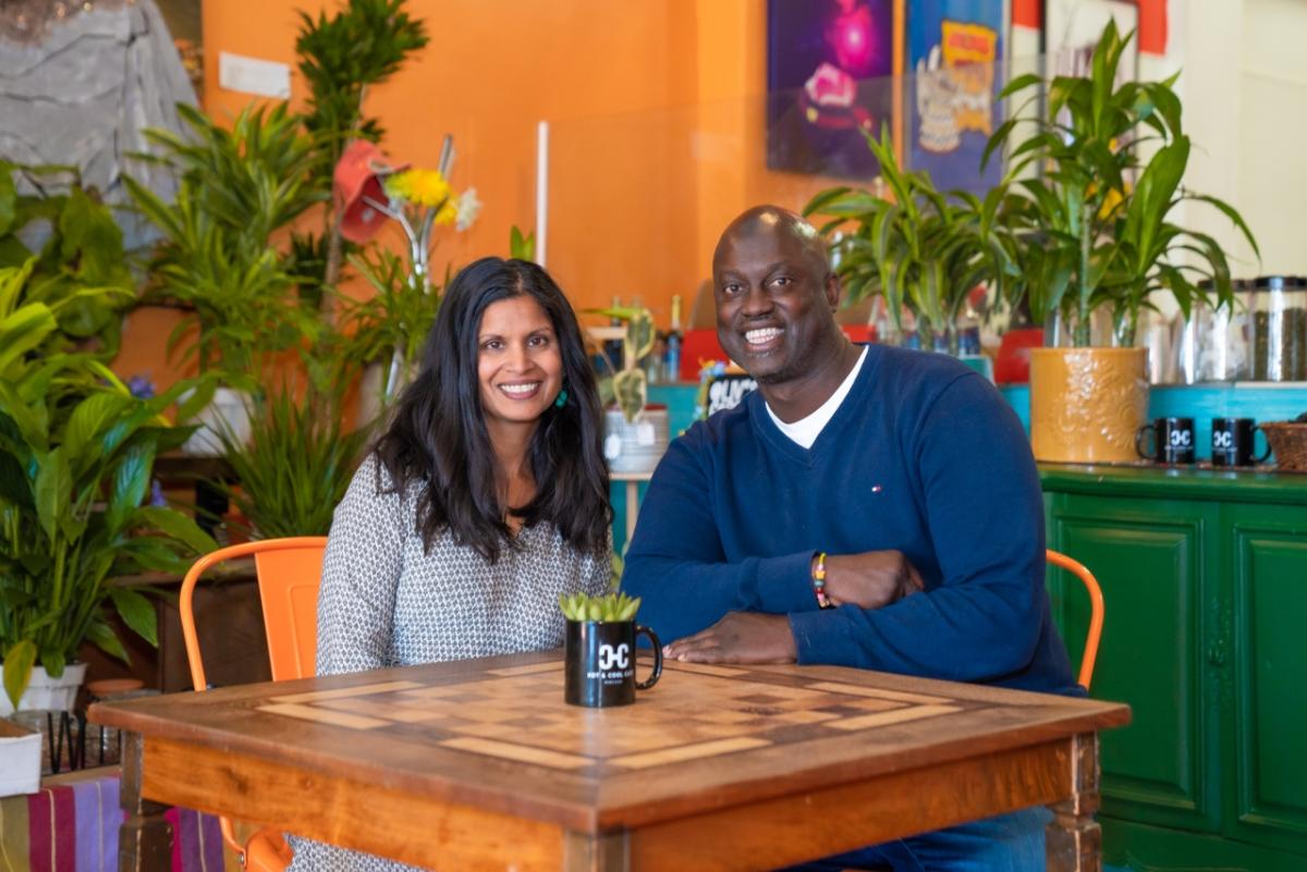 Husband and wife business owners sit at a table in their vegan cafe in Los Angeles.