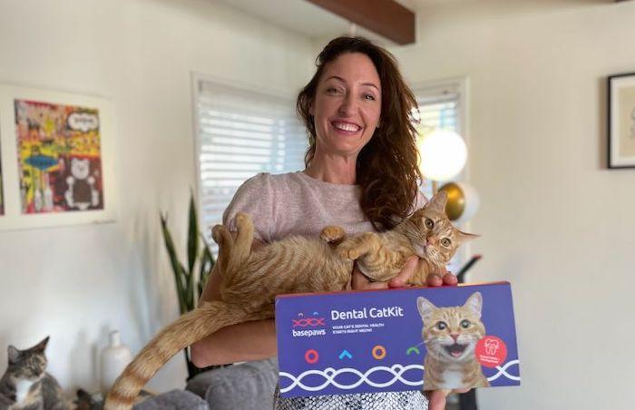 Anna Skaya holding her cat and a Dental CatKit
