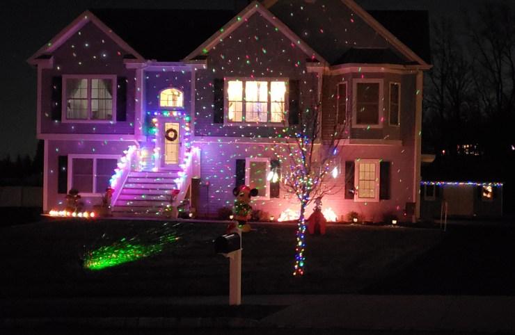 Home at night shown lit up with holiday lighting.