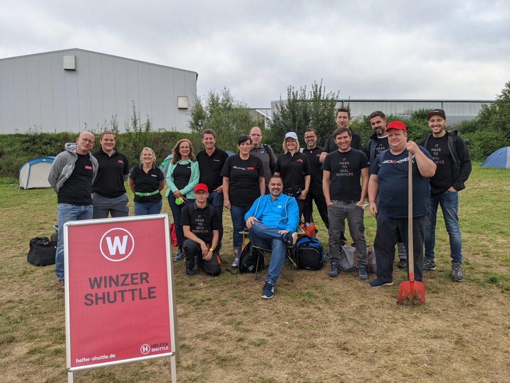 Employees gathered together by Winzer Shuttle sign
