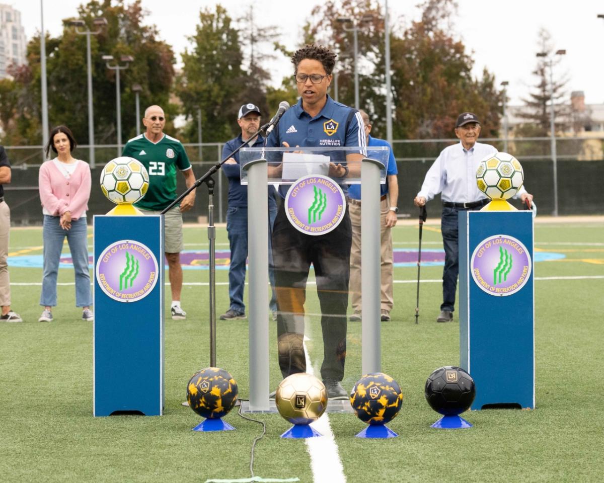 LA Galaxy legend Cobi Jones addresses the crowd from centerfield of "Tommy's Field" at Westwood Park Recreation Center.