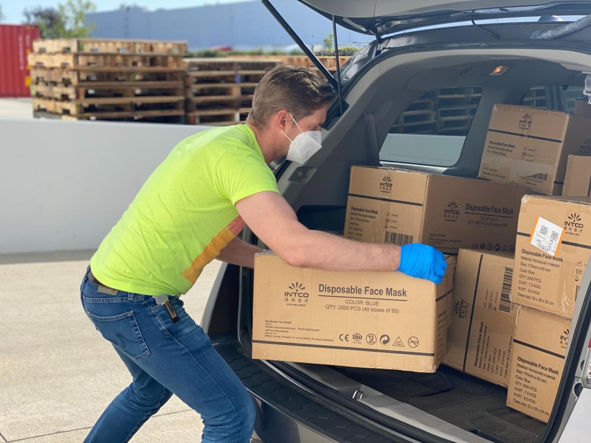 Man loading boxes in a car.