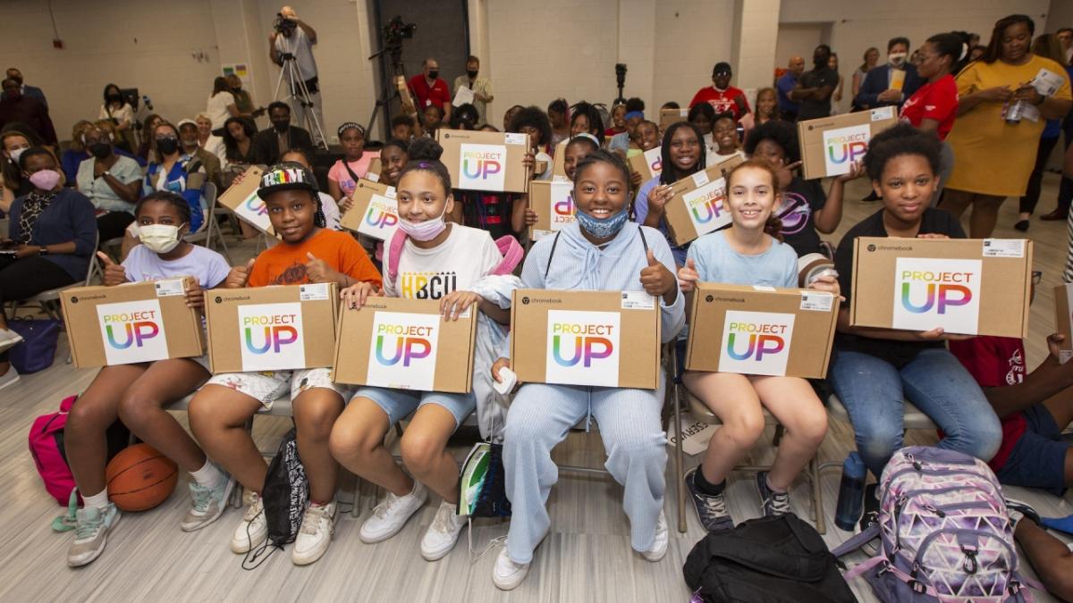 lage group of kids seated, pose with laptops from project UP