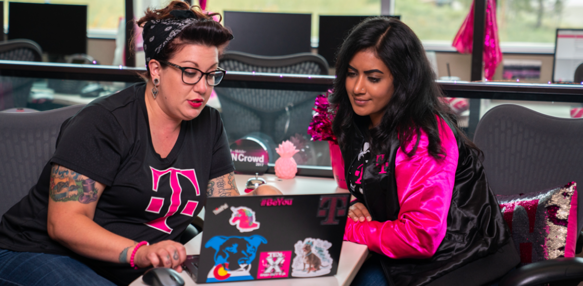 2 t-mobile employees using a laptop