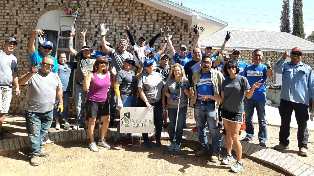 Volunteers in front of a "rebuilding together" sign
